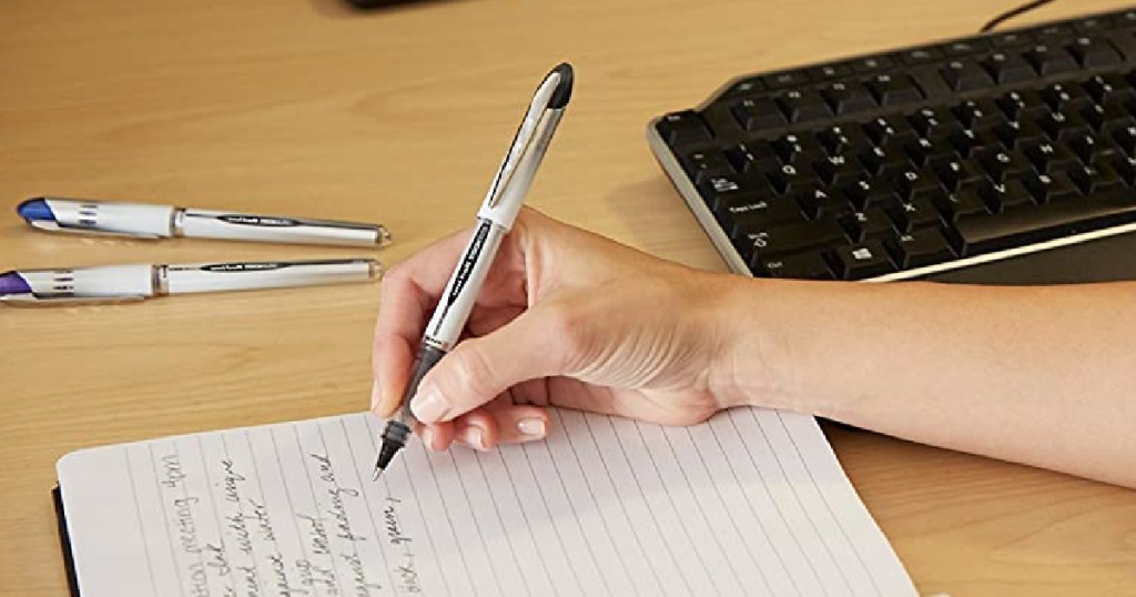 Woman writing with Uniball Rollerball pen