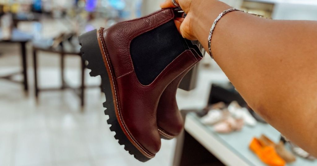 hand holding burgundy boots