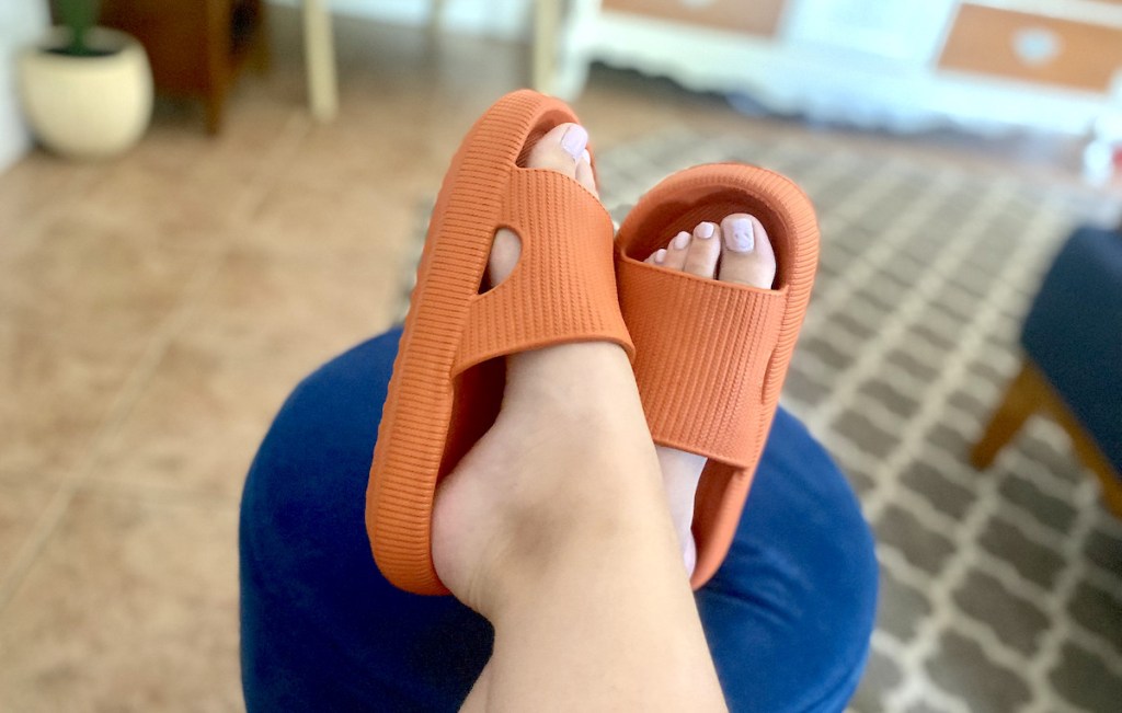 close up of feet wearing orange bathroom slippers