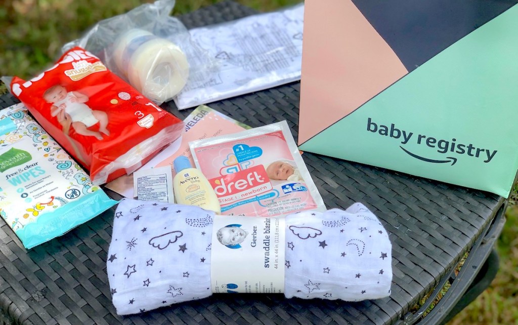 spread of baby sample items on outdoor table with amazon baby registry bag