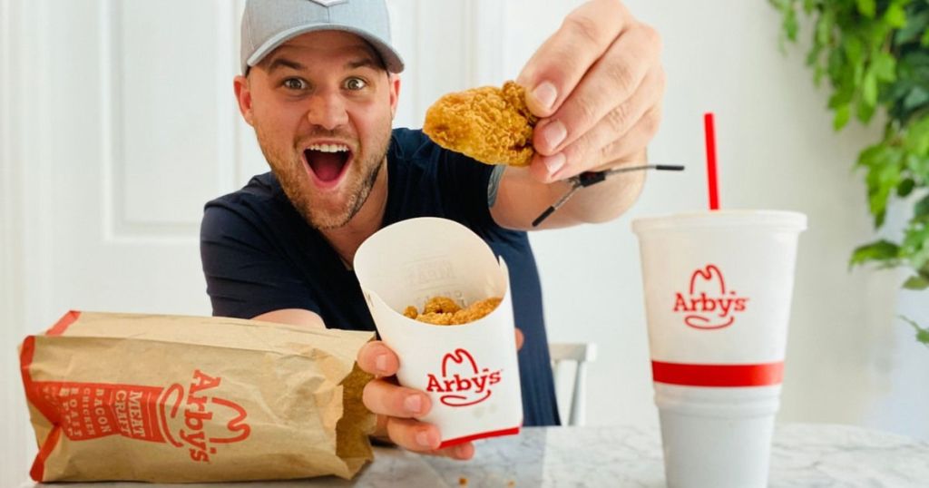 man holding up Arby's chicken nugget