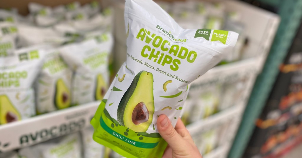 hand holding bag of avocado chips by store display