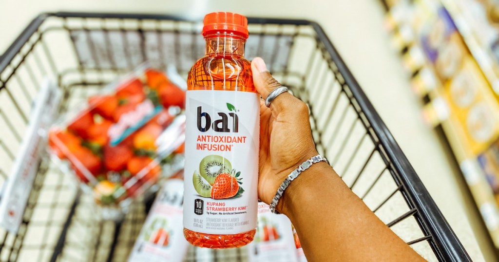bai strawberry kiwi bottle held over a cart of groceries