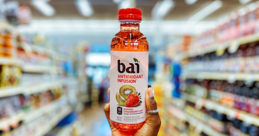 woman holding a bai beverage bottle up in-store