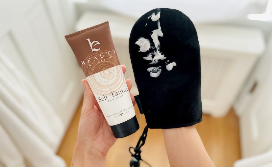 hands holding beauty by earth self tanner and black application mitt
