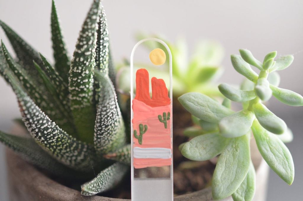 close up of glass nail file hand painted with desert and cactus scene