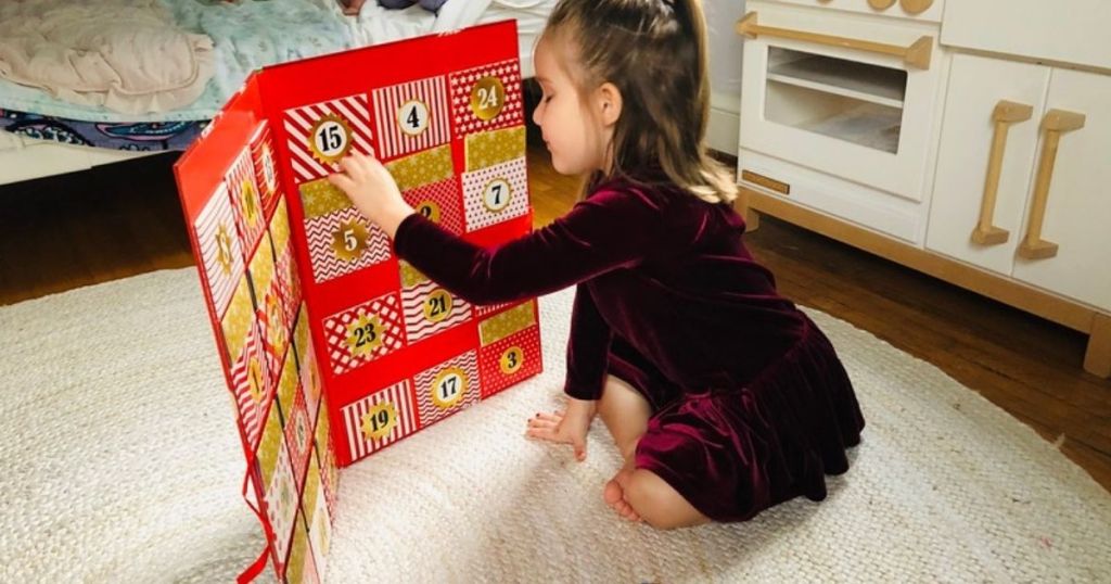 little girl looking at Disney advent calendar 