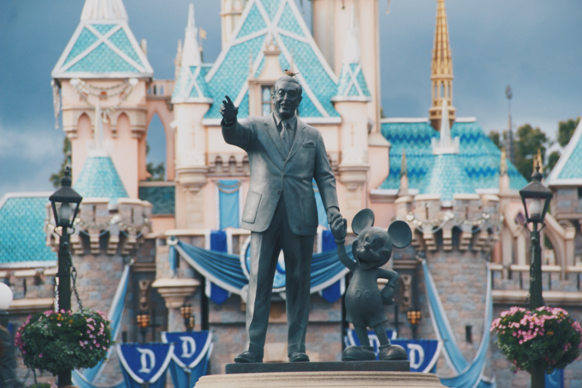 Entrance to Disney World with Mickey Mouse statue and Disney is one of the companies that pay for college