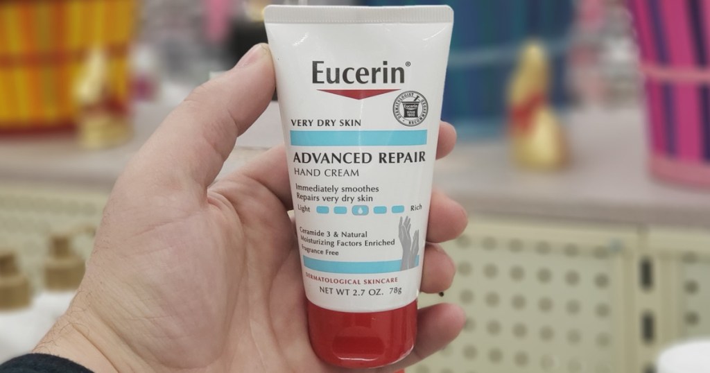 hand holding a bottle of eucerin hand lotion in a store