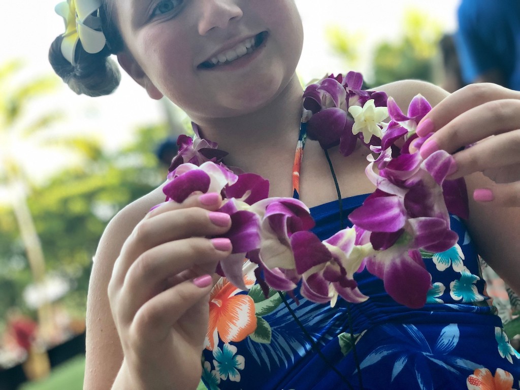 little girl wearing Hawaiian necklace and bathing suit 