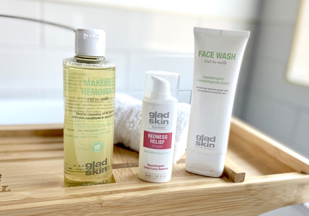 three gladskin skincare for redness beauty products sitting on bamboo tray in bathroom
