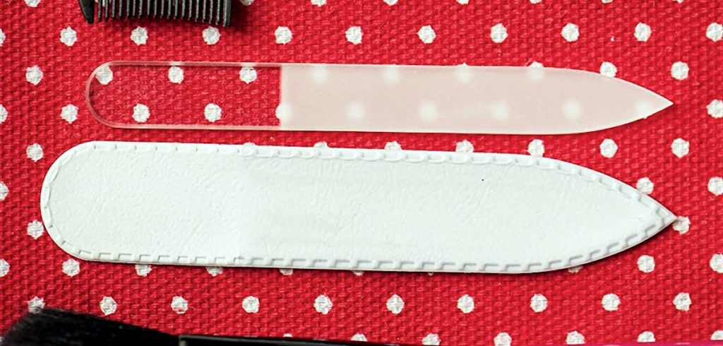 clear glass nail file with sleeve cover sitting on red and white polka dot surface