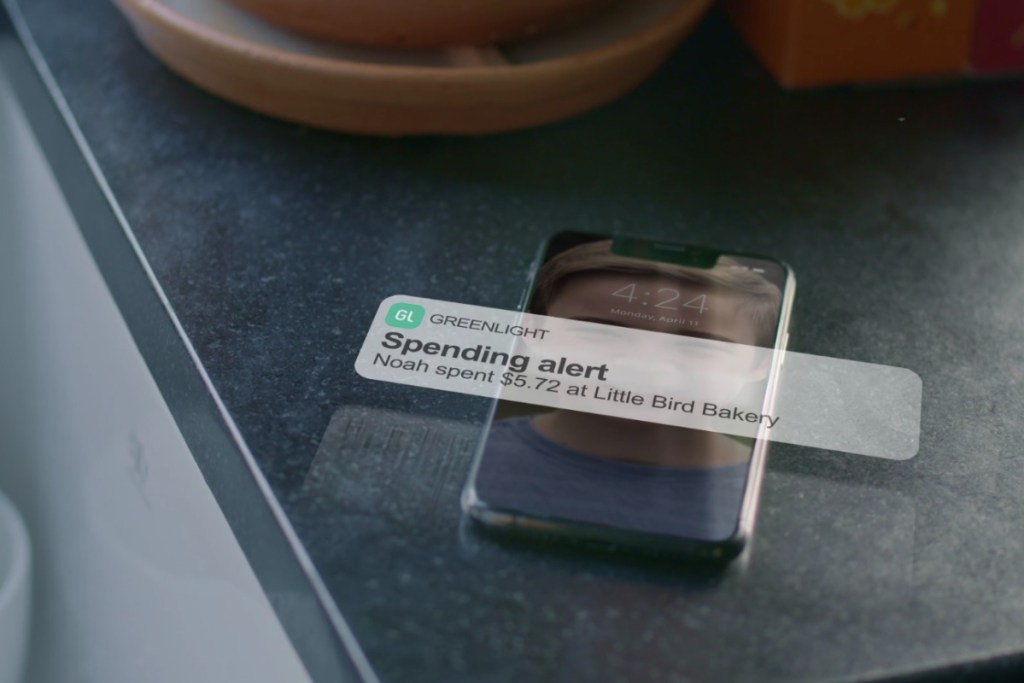 Phone on counter with Greenlight spending alert