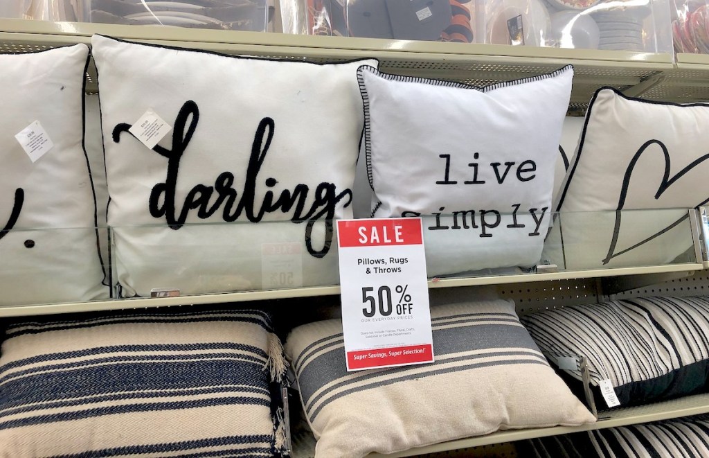 throw pillows on store shelves with hobby lobby sale sign