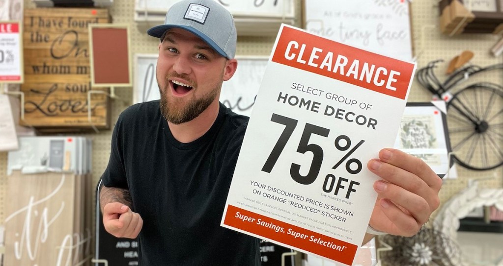 man holding a hobby lobby sale sign in store