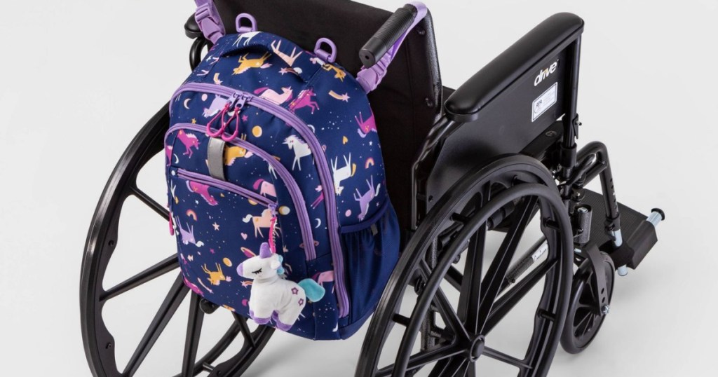 unicorn print backpack hanging on the back of a black wheelchair
