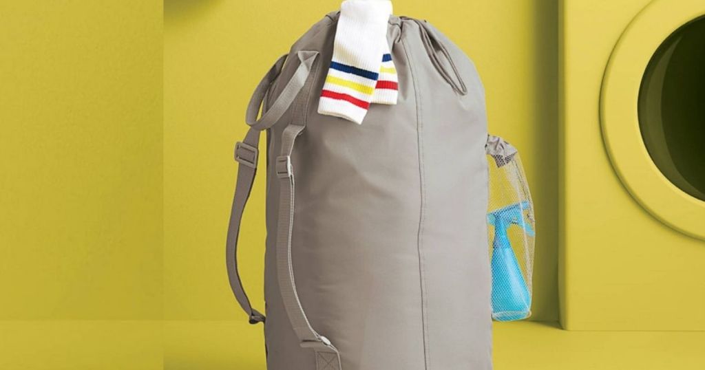 gray laundry backpack with socks on top and yellow background