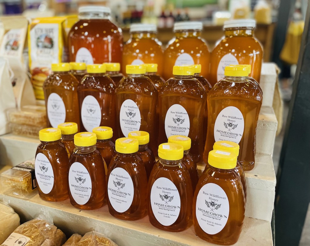 rows of local honey on farmers market stand