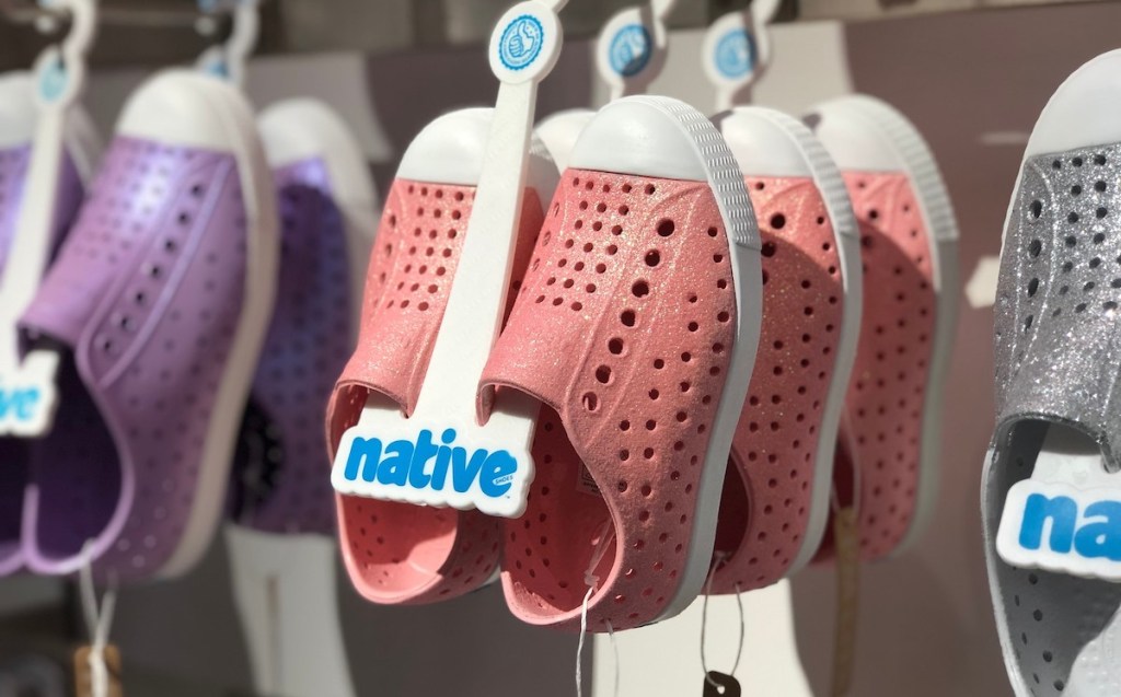 pink and purple native kids water shoes hanging up on store shelf