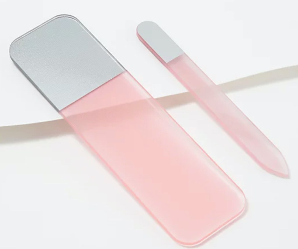 two pink glass nail files laying on white surface