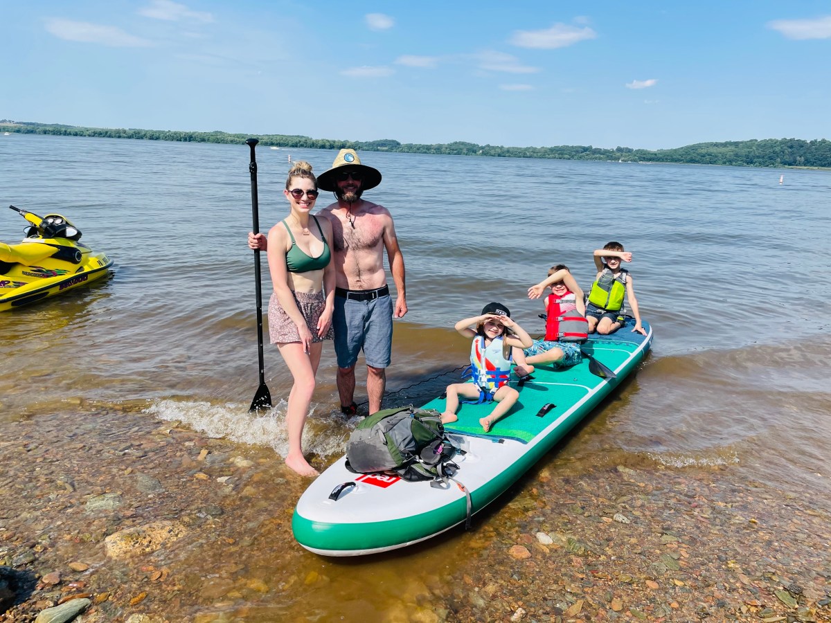 Family of five standing near tandem paddle board