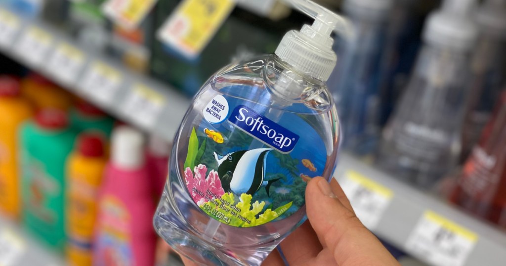 hand holding bottle of liquid soap with fish on it