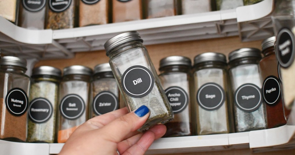 woman holding a bottle of dried dill