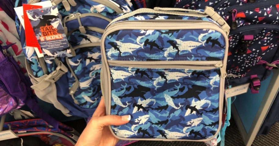 holding a shark lunchbox