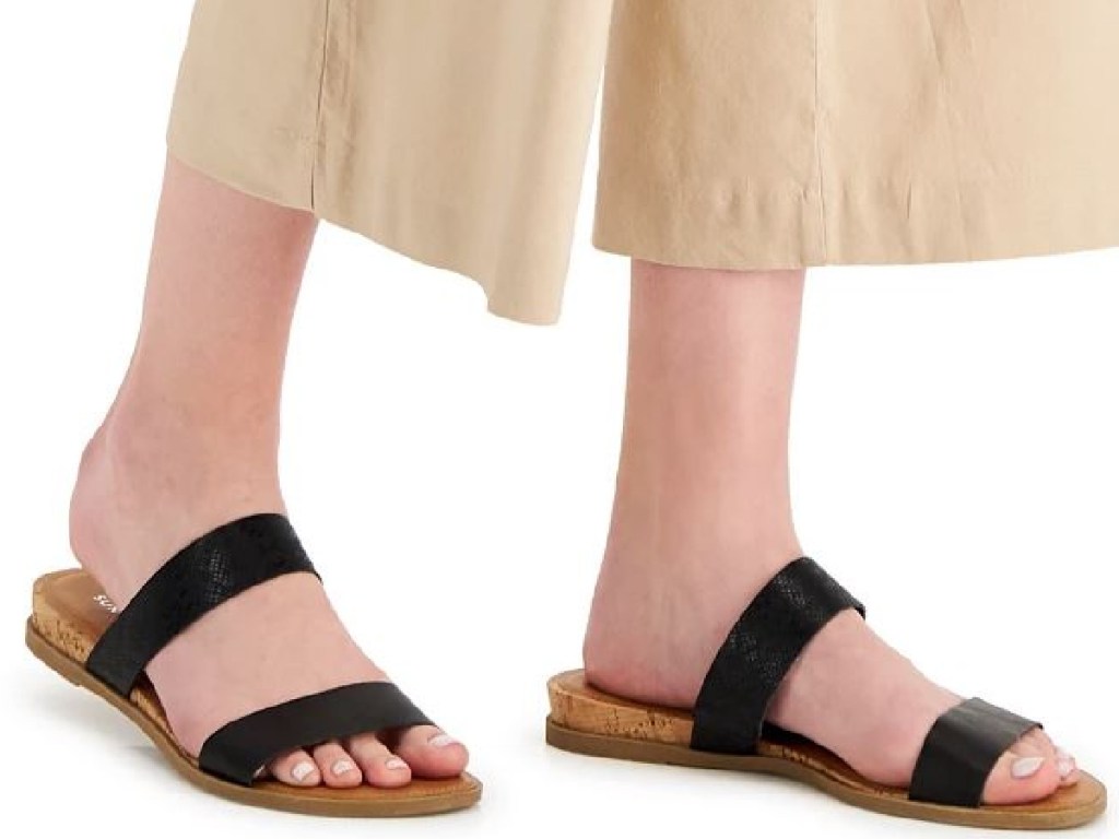 2 legs wearing black sandals