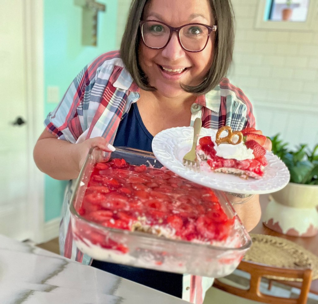 woman holding a strawberry pretzel salad dessert