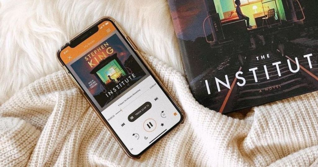phone with an audiobook playing next to same actual book