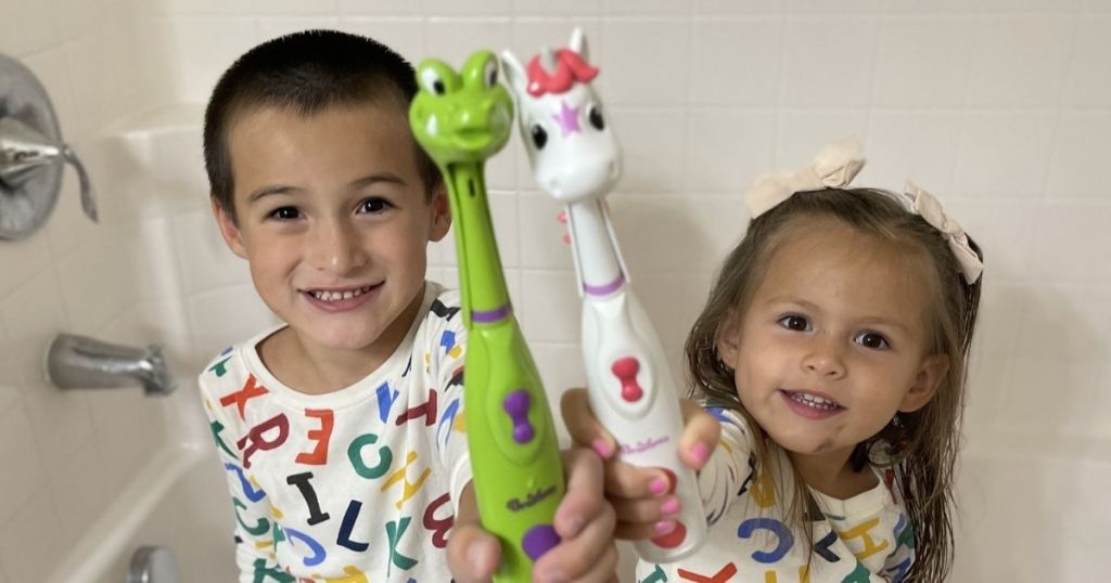 two kids holding toothbrushes