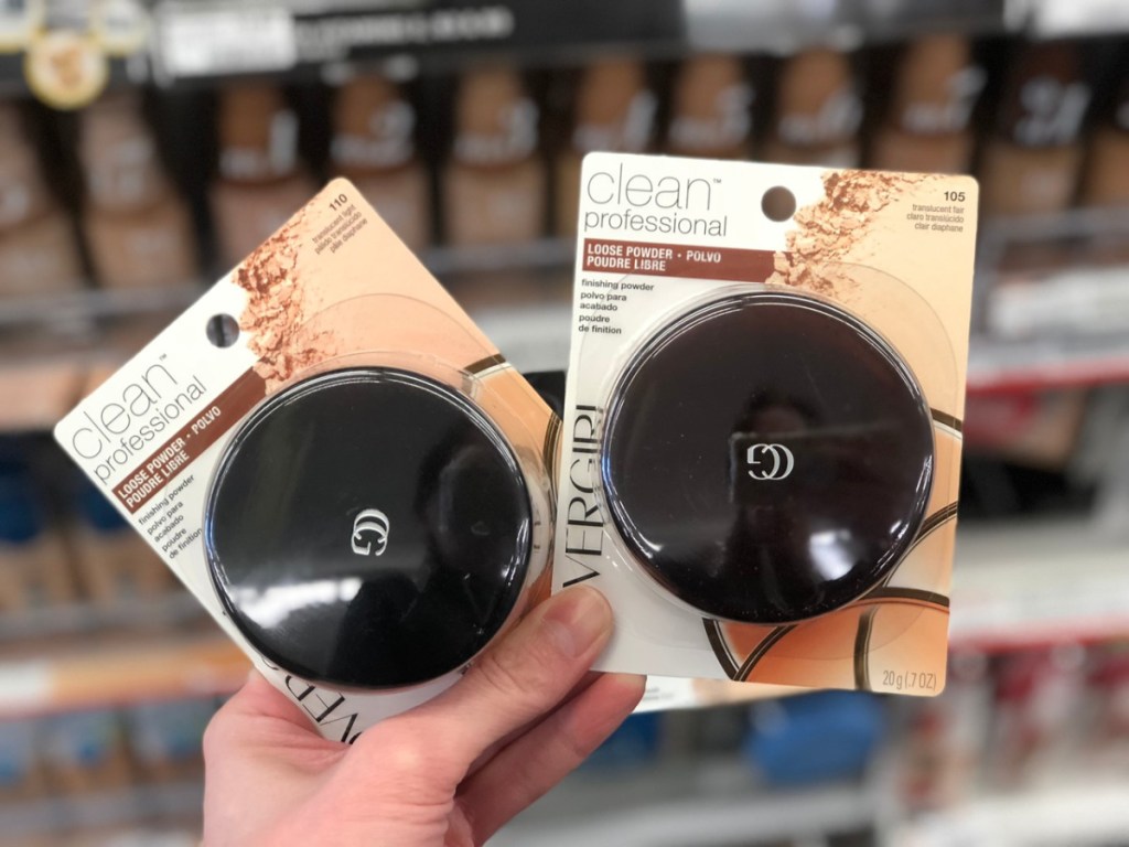 hand holding two loose makeup powders in store