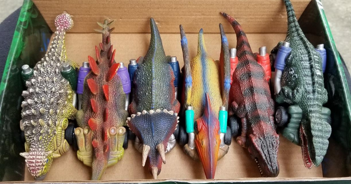dinosaur car toys lined up in a box