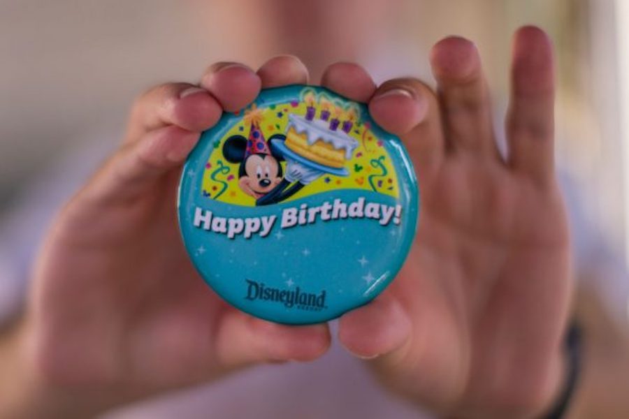 hands holding a Disney Birthday pin