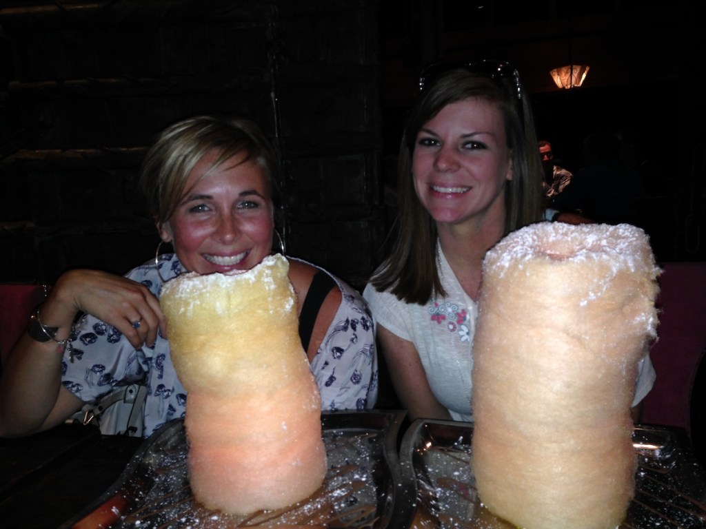 two woman sitting in dark with huge piles of cotton candy