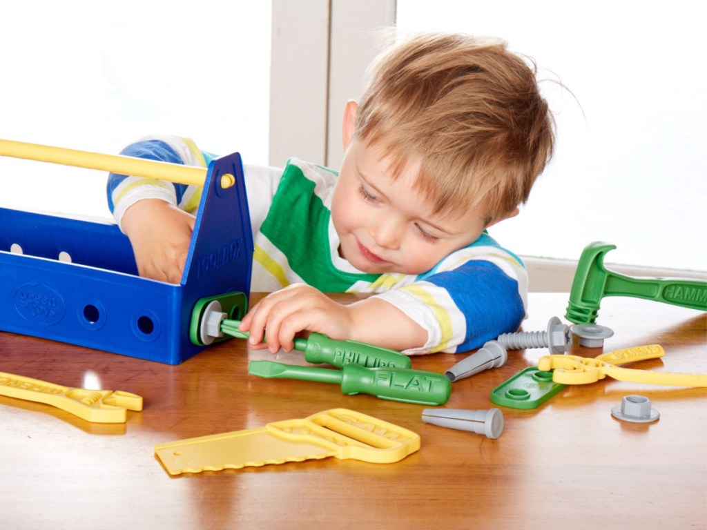 little boy plays with toy tools