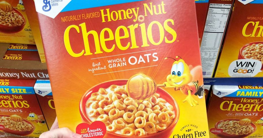 holding a large box of Honey Nut Cheerios