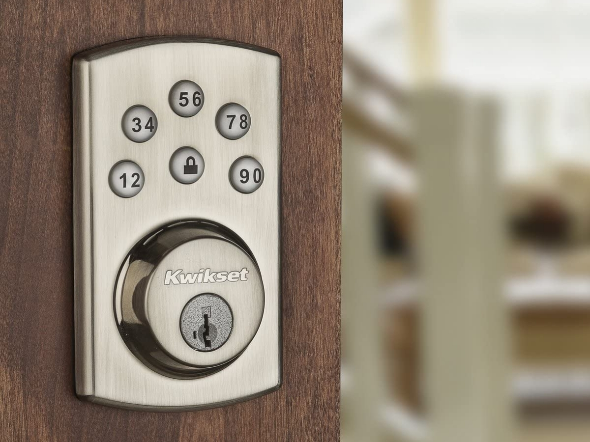 electronic deadbolt in silver on brown door with code