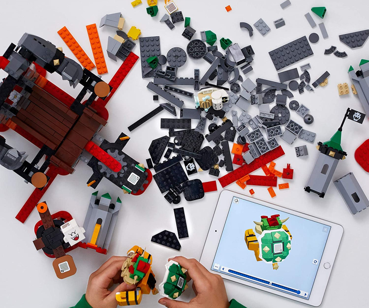 kids hands building Bowser themed LEGO set with digital directions