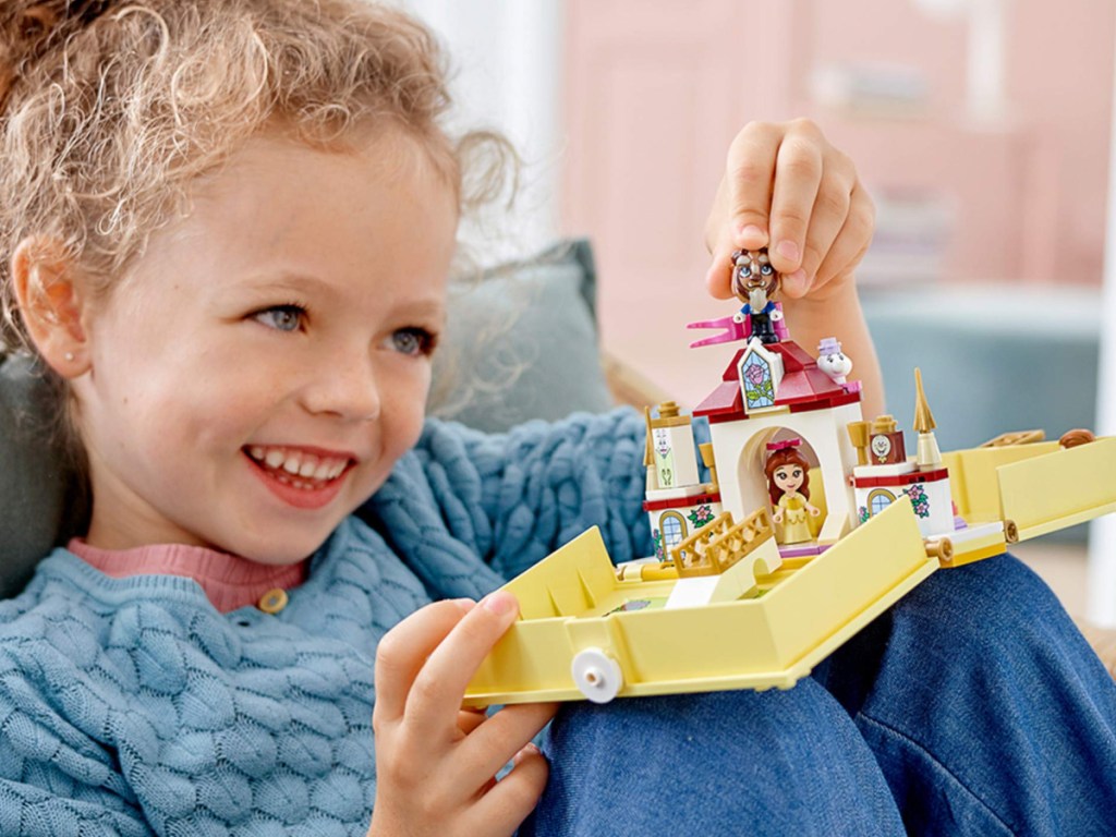 little girl playing with disney belle lego set 