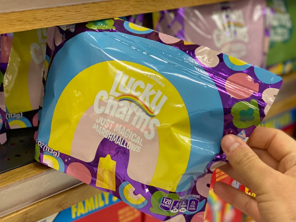 Person grabbing Lucky Charms Marshmallow Pack from store shelf