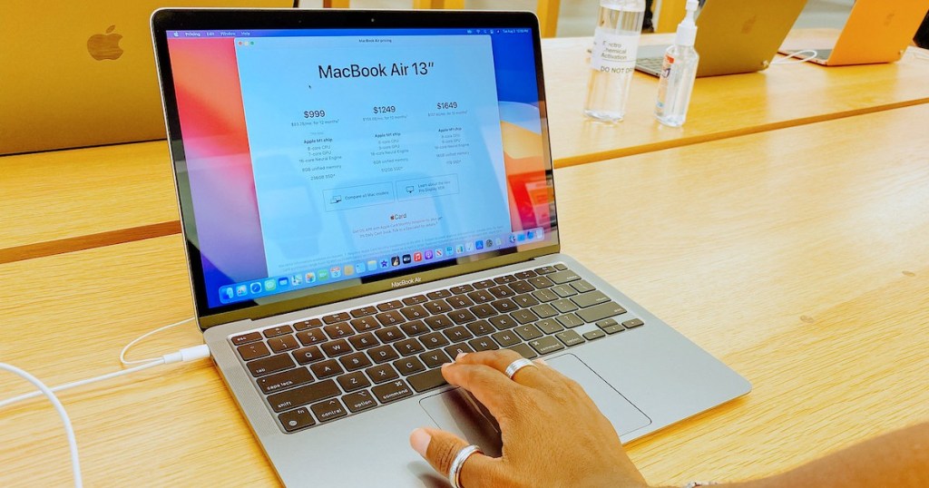 hand on keyboard of macbook air in apple store