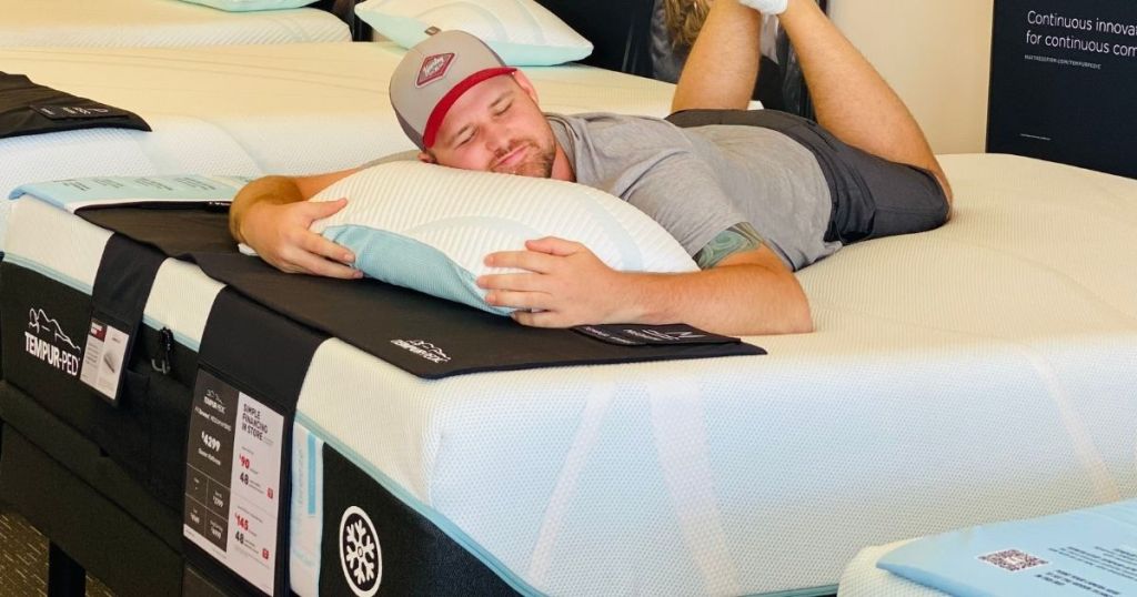 man laying on a mattress with a pillow