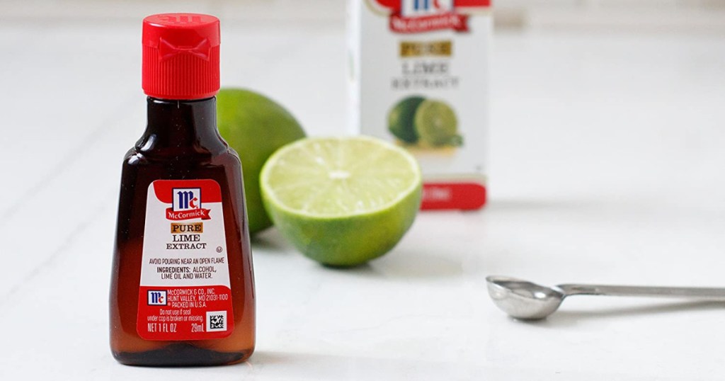 bottle of lime extract in front of lime and spoon