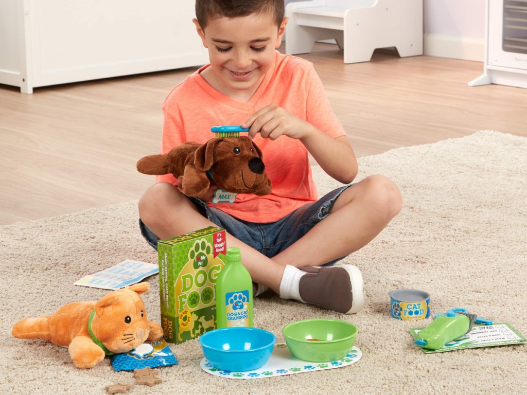 boy sitting on the floor playing with melissa and doug grooming set 