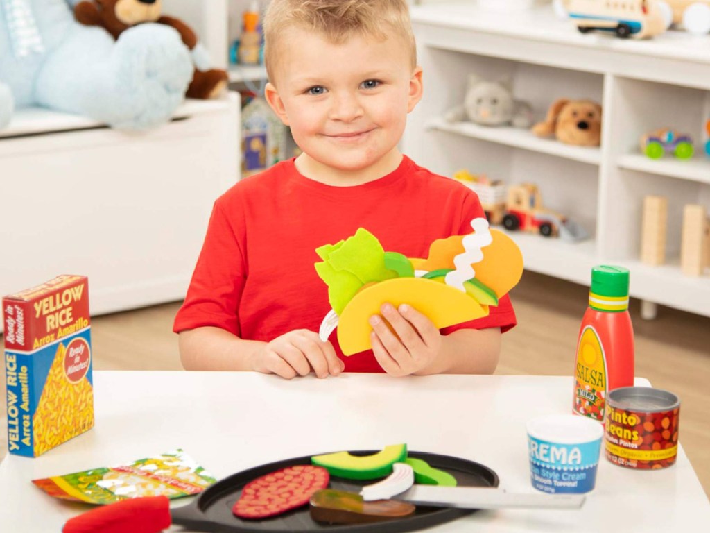 little boy playing with a melissa and doug tortilla set 