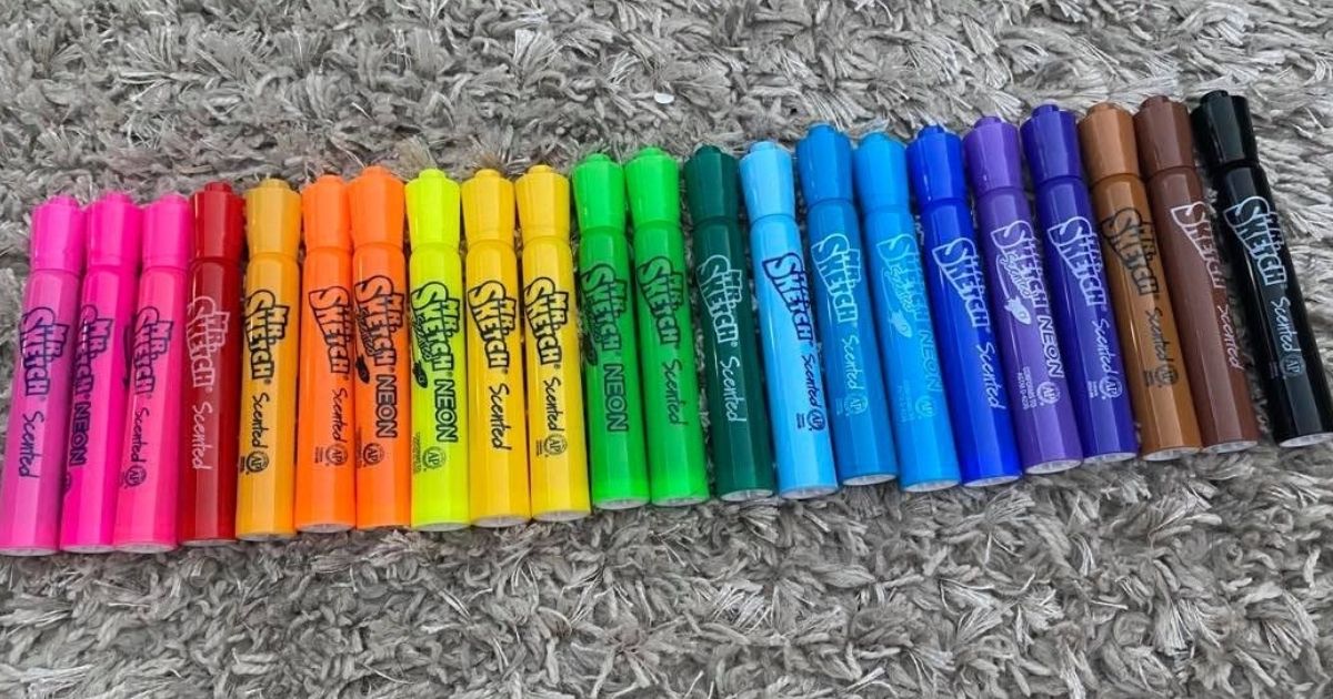 22 mr sketch markers in various colors lined up on a gray shag rug