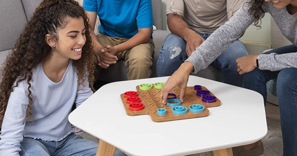 Family playing Otrio board game on table