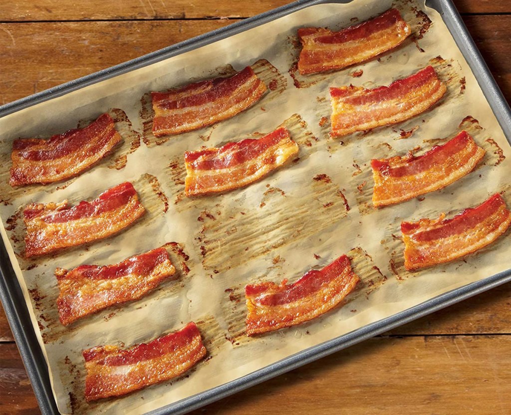 bacon on parchment paper and baking sheet